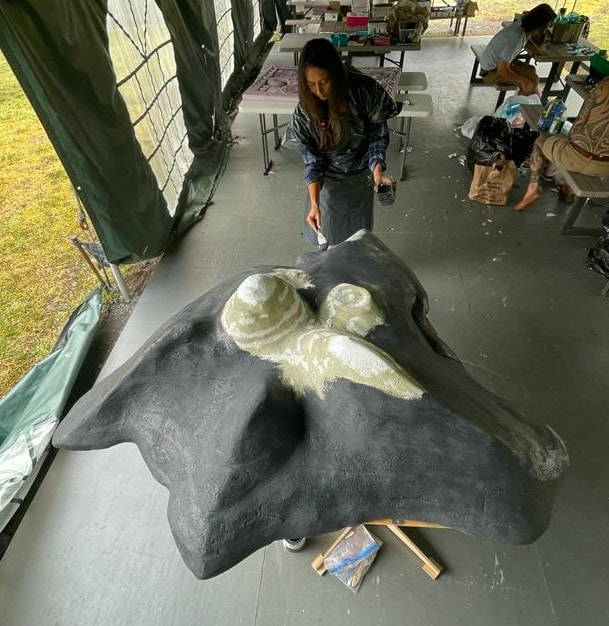 Lauren Blissett painting the relief map charcoal gray.